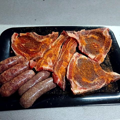 Seasoned beef chops and wors ready for the grill